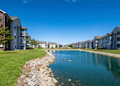 Thumbnail 31 of 37 - a large pond with apartment buildings on the other side of it