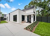 Thumbnail 30 of 46 - A modern house with a white exterior and a black roof.