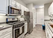 Thumbnail 32 of 47 - a kitchen with stainless steel appliances and white cabinets
