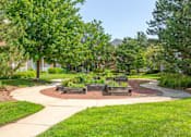 Thumbnail 19 of 47 - a sidewalk leading to a park with trees and benches