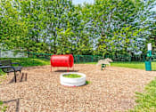 Thumbnail 12 of 47 - a fenced in play area with a red barrel and other playground equipment