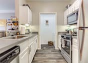 Thumbnail 31 of 47 - a kitchen with stainless steel appliances and white cabinets