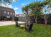 Thumbnail 32 of 46 - A backyard with a black fence and two black chairs.