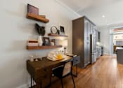 Thumbnail 18 of 32 - A modern kitchen with dark wood floors and a black chair.