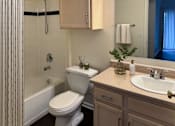 Thumbnail 33 of 41 - A white toilet sits next to a sink in a bathroom.