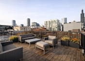 Thumbnail 26 of 32 - A wooden deck with furniture overlooking a city skyline.