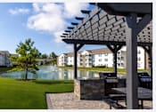 Thumbnail 37 of 37 - A patio with a table and chairs overlooks a pool and apartment buildings.