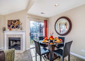 Thumbnail 18 of 23 - A dining room with a fireplace and a table set for a meal.