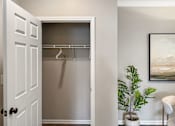 Thumbnail 37 of 47 - A white door with a black handle is open to a room with a plant and a painting.