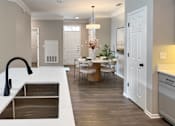 Thumbnail 21 of 47 - A kitchen with a sink and a dining table with chairs.