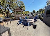 Thumbnail 21 of 21 - A patio with a gazebo, chairs, and a table.