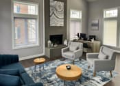 Thumbnail 2 of 37 - a living room with a blue couch and chairs and a rug