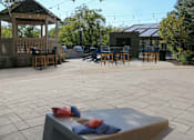 Thumbnail 9 of 21 - A gazebo is surrounded by a patio with a table and chairs.