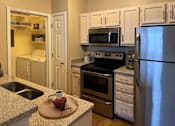 Thumbnail 30 of 41 - A kitchen with a refrigerator, oven, and sink.