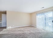 Thumbnail 20 of 23 - A room with a carpeted floor and a sliding glass door.