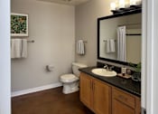 Thumbnail 22 of 41 - A bathroom with a toilet, sink, and mirror.