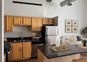 Thumbnail 19 of 41 - A modern kitchen with wooden cabinets and black appliances.