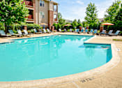 Thumbnail 12 of 41 - Sparkling outdoor pool surrounded by pristine landscaping