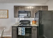 Thumbnail 14 of 37 - a kitchen with black appliances and wood cabinets