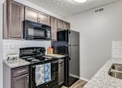 Thumbnail 15 of 37 - our apartments have a modern kitchen with black appliances and granite counter tops