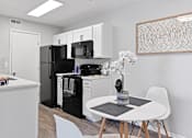 Thumbnail 1 of 37 - a kitchen with a white table and a black refrigerator