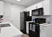 Thumbnail 12 of 37 - an empty kitchen with black appliances and white cabinets