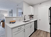 Thumbnail 13 of 37 - a kitchen with white cabinets and a sink and a refrigerator