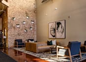 Thumbnail 5 of 41 - a lobby with a couch and chairs and a brick wall
