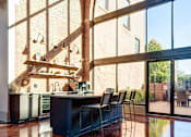 Thumbnail 2 of 41 - a living room with large windows and a bar with chairs