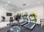Thumbnail 8 of 23 - A gym with treadmills and exercise bikes.