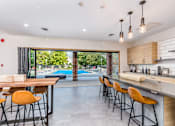 Thumbnail 4 of 23 - A modern kitchen with a pool outside the window.
