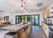 Thumbnail 3 of 23 - A modern kitchen with wooden cabinets and stainless steel appliances.