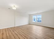 Thumbnail 32 of 36 - Empty room with wooden floor and a window.