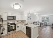 Thumbnail 14 of 36 - A modern kitchen with white cabinets and stainless steel appliances.