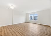 Thumbnail 31 of 36 - Empty room with wooden floor and a window showing a cityscape outside.