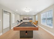 Thumbnail 8 of 36 - A pool table is in the middle of a room with a picture on the wall and a window with blinds.