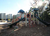 Thumbnail 6 of 9 - A playground with a green slide and a red ladder.
