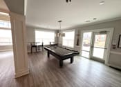 Thumbnail 7 of 75 - A spacious room with a pool table and a view of the outside.