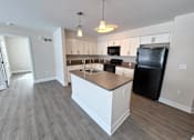 Thumbnail 60 of 75 - A kitchen with black appliances and white cabinets.
