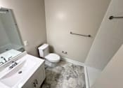 Thumbnail 50 of 75 - A bathroom with a toilet, sink, and a shower.