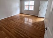 Thumbnail 26 of 29 - A room with wooden flooring and a window with blinds.