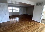 Thumbnail 22 of 29 - A room with wooden flooring and white walls.