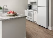 Thumbnail 17 of 43 - a kitchen with white appliances and a bowl of fruit on the counter