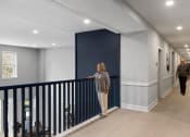 Thumbnail 15 of 43 - a hallway with white walls and a blue wall with mannequins in it