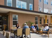 Thumbnail 4 of 43 - a group of people sitting at a table outside of a building