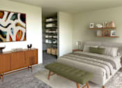 Thumbnail 2 of 8 - A bedroom with a large bed and a wooden cabinet.
