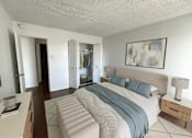 Thumbnail 2 of 26 - A bedroom with a large bed and a painting on the wall.