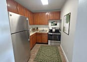Thumbnail 3 of 26 - A kitchen with a refrigerator, oven, and sink.