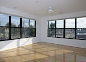 Thumbnail 13 of 16 - A room with a ceiling fan and large windows.