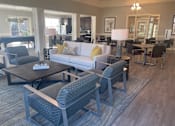 Thumbnail 3 of 7 - A living room with a grey couch and a coffee table.